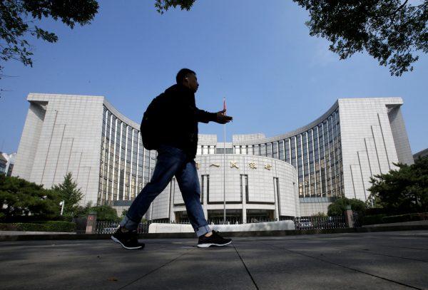 A man walks past the headquarters of the People's Bank of China, the central bank, in Beijing, on Sept. 28, 2018. (Jason Lee/Reuters)