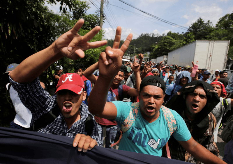 Honduran migrants, part of a caravan trying to reach the U.S., gesture while arriving to the border between Honduras and Guatemala, in Agua Caliente, Guatemala October 15, 2018. (Jorge Cabrera/Reuters)