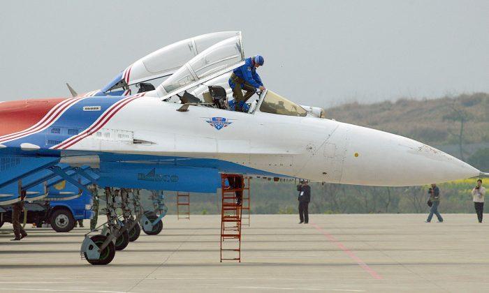 A pilot gets in a Russian Su-27 fighter jet prior to a rehearsal of an aerobatics show. (LIU JIN/AFP/Getty Images)