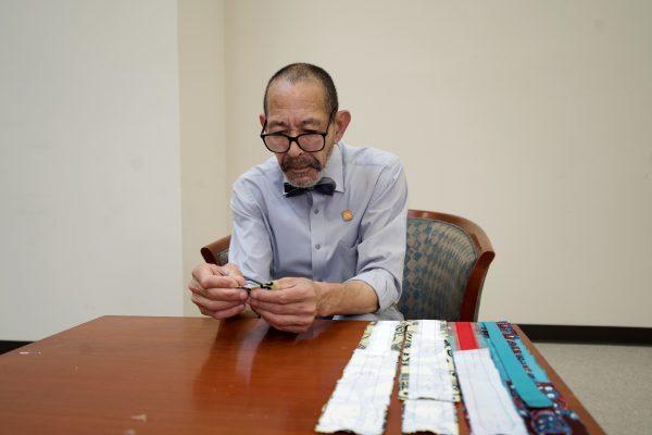 Gregory Bruce examining fabric. (Shenghua Sung/The Epoch Times)