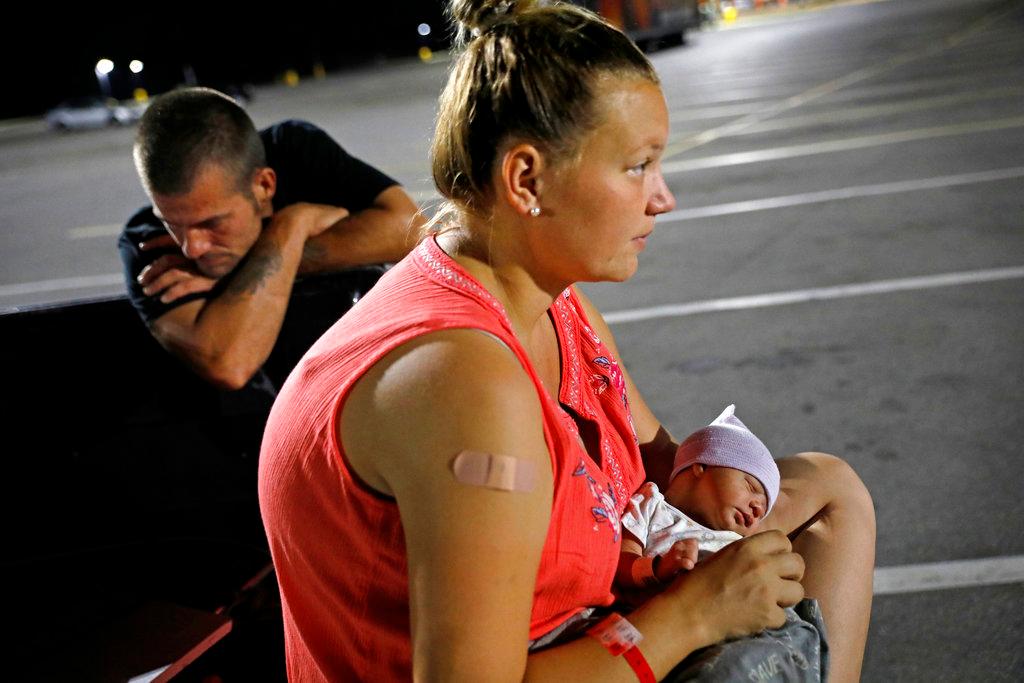 Lorrainda Smith, right, and husband Wilmer Capps prepare to spend the first night out of the hospital with their two-day-old son Luke in a parking lot in Panama City, Fla. on Oct. 15, 2018. (AP Photo/David Goldman)