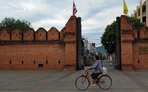 A Thai woman rides her bicycle past the Tha Phae gate in Chiang Mai, some 700kms from Bangkok, on May 23, 2010. (Manan Vatsyayana/AFP/Getty Images)