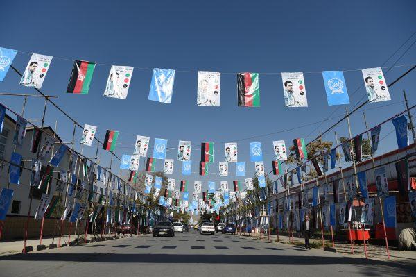 Afghan commuters drive along as posters of candidate Ahamd Tamin Jurat are installed during the parliamentary election campaign, in Kabul, Afghanistan, on Oct. 2, 2018. (Wakil Kohsar/AFP/Getty Images)