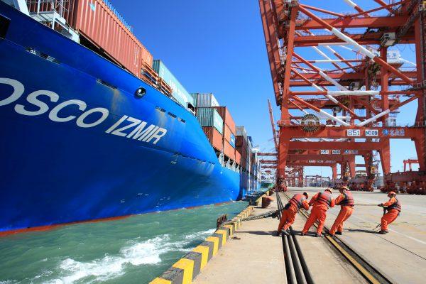 Workers help to dock a China Ocean Shipping Company (COSCO) container ship at a port in Qingdao, Shandong Province, China on Oct. 19, 2018. (Reuters)