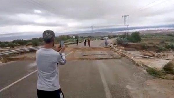 An unidentified man records video as a bridge crumbles over the Oued El Hogueff river in Tunisia on Oct. 17, 2018. (Shehab al-Saadawi via Storyful)