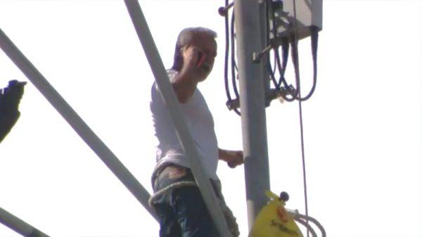 Pablo Torres talks to police on his cell phone from his perch atop a cell tower in Hialeah, Florida on Oct. 19. (Fox screenshot)