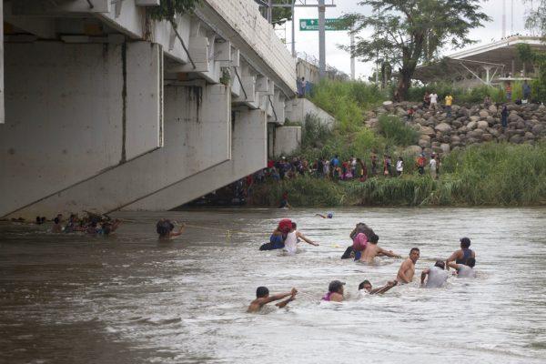 A group of Central American migrants wade across the Suchiate River, on the the border between Guatemala and Mexico, in Ciudad Hidalgo, Mexico, on Oct. 20, 2018. (Moises Castillo/AP Photo)