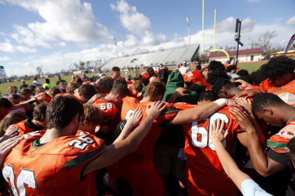 Coaches and players from Mosley High pray together after their loss to Pensacola High, in the aftermath of Hurricane Michael in Panama City, Fla., Oct. 20, 2018. (AP Photo/Gerald Herbert)