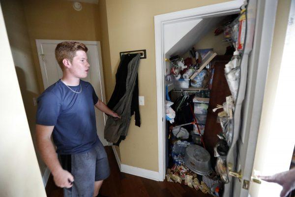 Mike Maddox, quarterback for the Mosley High football team, shows the closet in which he hid with three adults and five dogs during Hurricane Michael, in his damaged home, in Lynn Haven, Fla., Oct. 19, 2018. (AP Photo/Gerald Herbert)