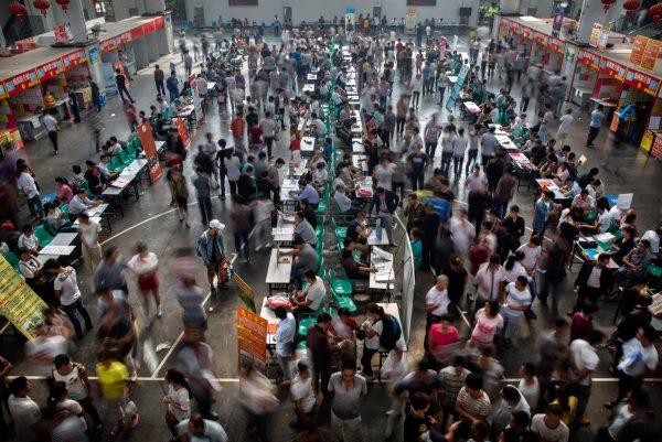 Chinese workers gather around potential employers at a local job center on September 18, 2015 in Yiwu, Zhejiang Province, China. (Kevin Frayer/Getty Images)