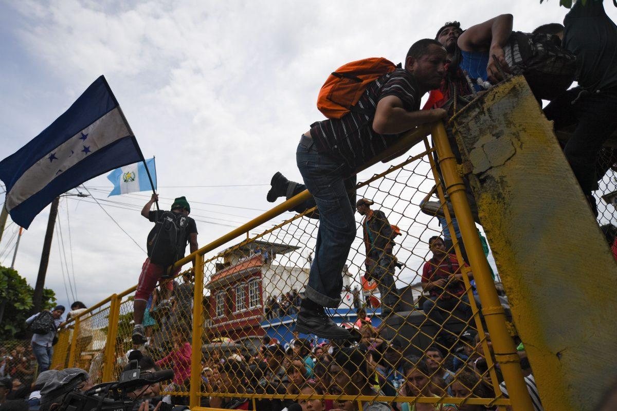 Honduran and other migrants heading in a caravan to the United States illegally climb the gate of the Guatemala-Mexico international border bridge in Ciudad Hidalgo, Chiapas state, Mexico, on Oct. 19, 2018. (Pedro Pardo/AFP/Getty Images)