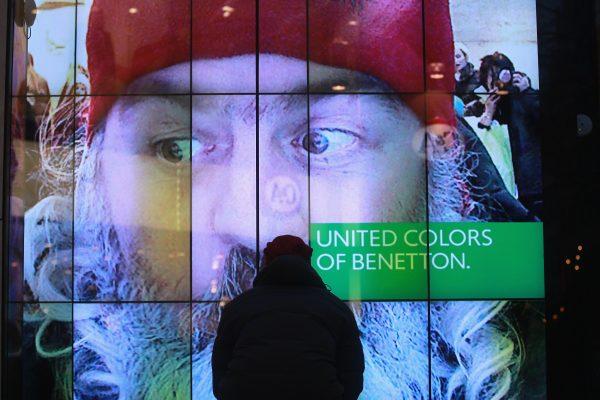 The United Colors of Benetton logo is seen in a storefront as people walk past decorated shops at a pedestrian zone in downtown Munich, Germany, on Dec. 9, 2011. (Johannes Simon/Getty Images)