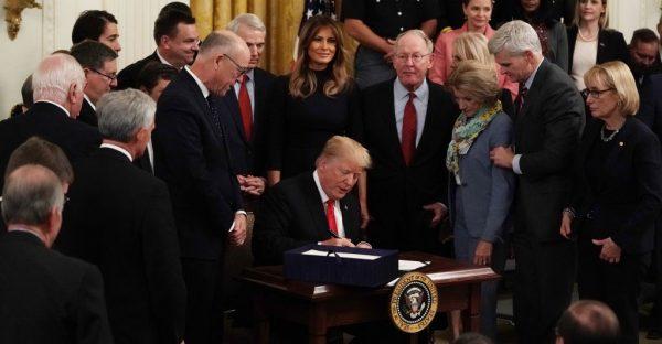 Flanked by lawmakers and first lady Melania Trump, President Donald Trump participates in a bill signing to dedicate more resources to fight the opioid crisis during an East Room event at the White House on Oct. 24, 2018. (Alex Wong/Getty Images)