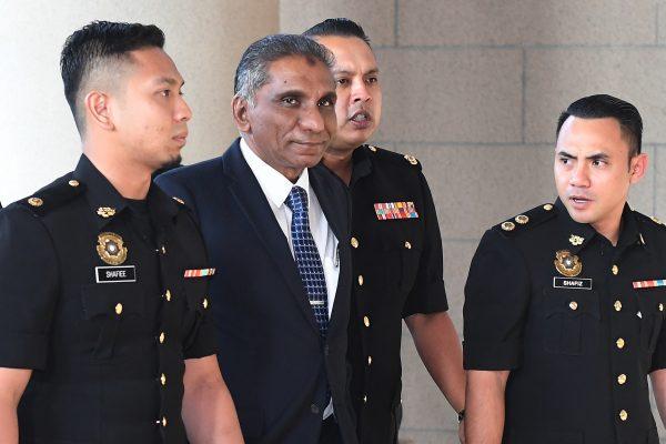 Malaysia's senior finance ministry official, Mohamad Irwan Serigar Abdullah (2nd-L) is escorted by police to the courthouse in Kuala Lumpur, on Oct. 25, 2018. (Mohd Rasfan/AFP/Getty Images)