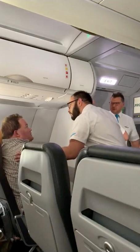 Crewmembers attempt to calm down the distressed passenger, on Oct. 23, 2018. (Kathleen Ingham via Storyful)