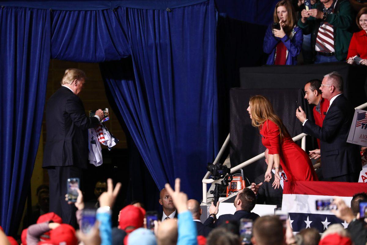 President Donald Trump signs a memento for an audience member at a Make America Great Again rally in Charlotte, N.C., on Oct. 26, 2018. (Charlotte Cuthbertson/The Epoch Times)