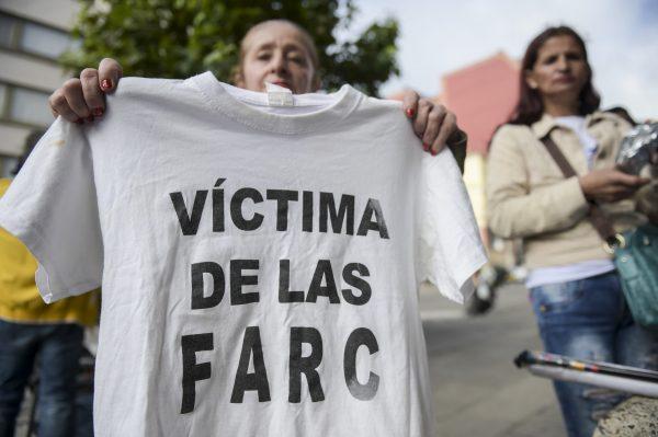 A woman holds a T-shirt reading “Victim of the FARC” during a protest outside at the Special Jurisdiction for Peace (JEP) headquarters in Bogota on July 13, 2018. (Raul Arboleda/AFP/Getty Images)