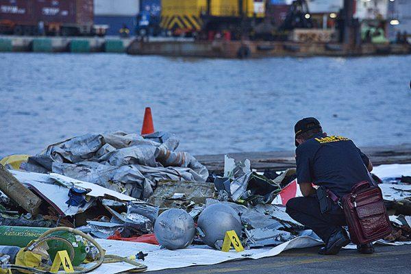 A forensic investigator looks through the remains of Lion Air flight JT610 at the Tanjung Priok port in Jakarta, Indonesia on Oct. 29, 2018. (Ed Wray/Getty Images)