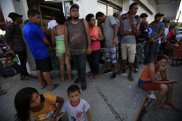 Migrants wait in a slow-moving line to collect money transfers sent by relatives back home, as a caravan of Central Americans trying to reach the U.S. border halts for a rest day in Tapanatepec, Oaxaca state, Mexico, on Oct. 28, 2018. (Rebecca Blackwell/AP)