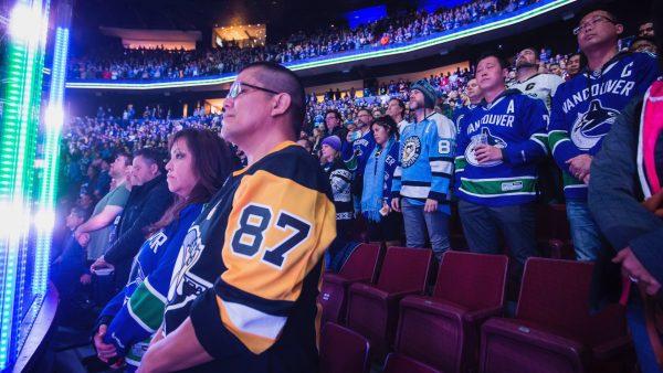 Spectators stand during a moment of silence for the victims of a shooting at a Pittsburgh synagogue, before the Vancouver Canucks and the Pittsburgh Penguins play an NHL hockey game in Vancouver, British Columbia, on Oct. 27, 2018. (Darryl Dyck/The Canadian Press/AP)