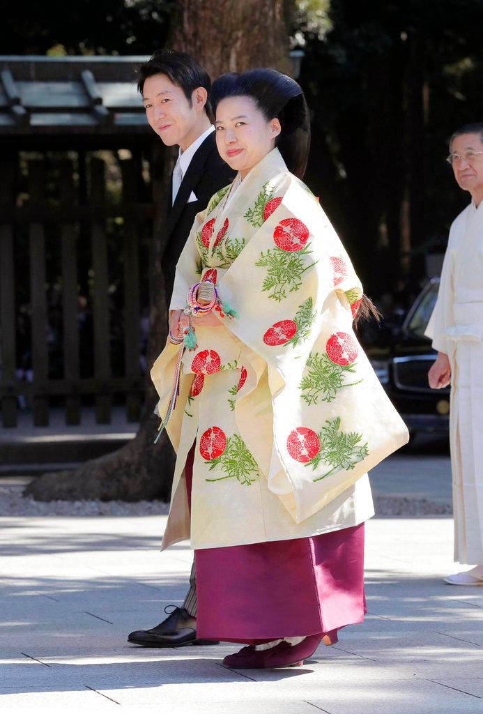 Japanese Princess Ayako, front, the third daughter of the late Prince Takamado, dressed in traditional ceremonial gown, and Japanese businessman Kei Moriya, rear, arrive at Meiji Shrine for their wedding ceremony in Tokyo, Oct. 29, 2018. (Kyodo News via AP)
