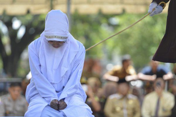 An Indonesian 21-year old woman is caned in public after being caught in close proximity with her boyfriend in Banda Aceh on Oct. 29, 2018. (Chaideer Mahyuddin /AFP/Getty Images)
