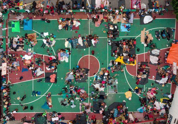 Honduran migrants heading in a caravan to the US, resting in a basketball court in San Pedro Tapanatepec, Oaxaca state, southern Mexico, on Oct. 28, 2018. (Guillermo Arias/AFP/Getty Images)