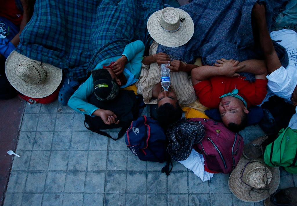 Migrants sleep packed together in a church courtyard at nightfall, as a thousands-strong caravan of Central Americans hoping to reach the U.S. border stops for the night in Niltepec, Oaxaca state, Mexico on Oct. 29, 2018. (AP Photo/Rebecca Blackwell)