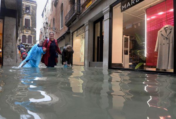 People walk in a flooded street of Venice, Italy, on Oct. 29, 2018. (Andrea Merola/ANSA via AP)