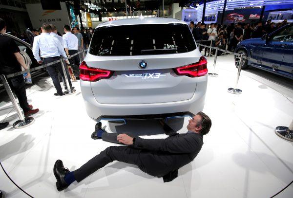 A man checks the BMW iX3 electric concept car during a media preview at the Auto China 2018 motor show in Beijing on April 25, 2018. (Jason Lee/Reuters)