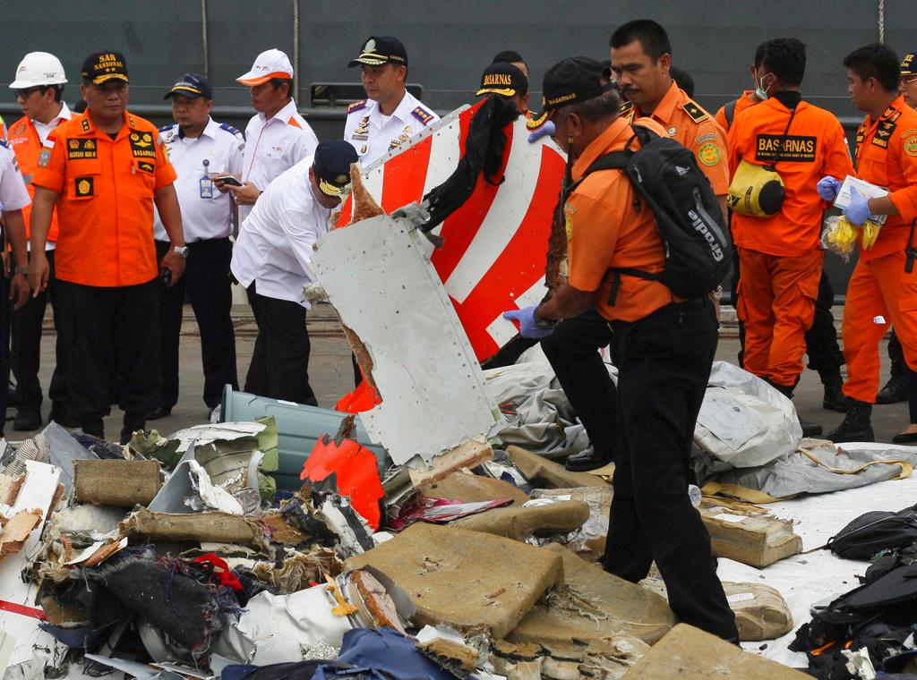 A rescuer inspects a part of Lion Air plane flight JT 610 retrieved from the waters where it's believed to have crashed at Tanjung Priok Port in Jakarta, Indonesia, Oct. 30, 2018. (AP Photo/Binsar Bakara)