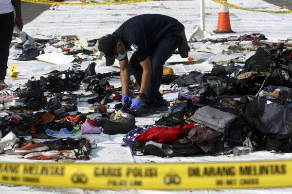 An investigator inspect debris from Lion Air flight JT 610 that crashed into the Java sea at Tanjung Priok Port in Jakarta, Indonesia, on Nov. 2, 2018. (Binsar Bakkara/AP)