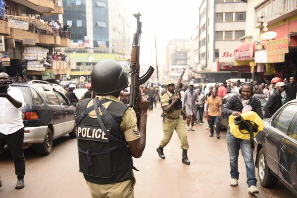 Ugandan police officers lift their AK-47 riffle during demonstrations in Kampala, Uganda, on July 11, 2018 to protest a controversial tax on use of social media platforms. (Isaac Kasamani/AFP/Getty Images)