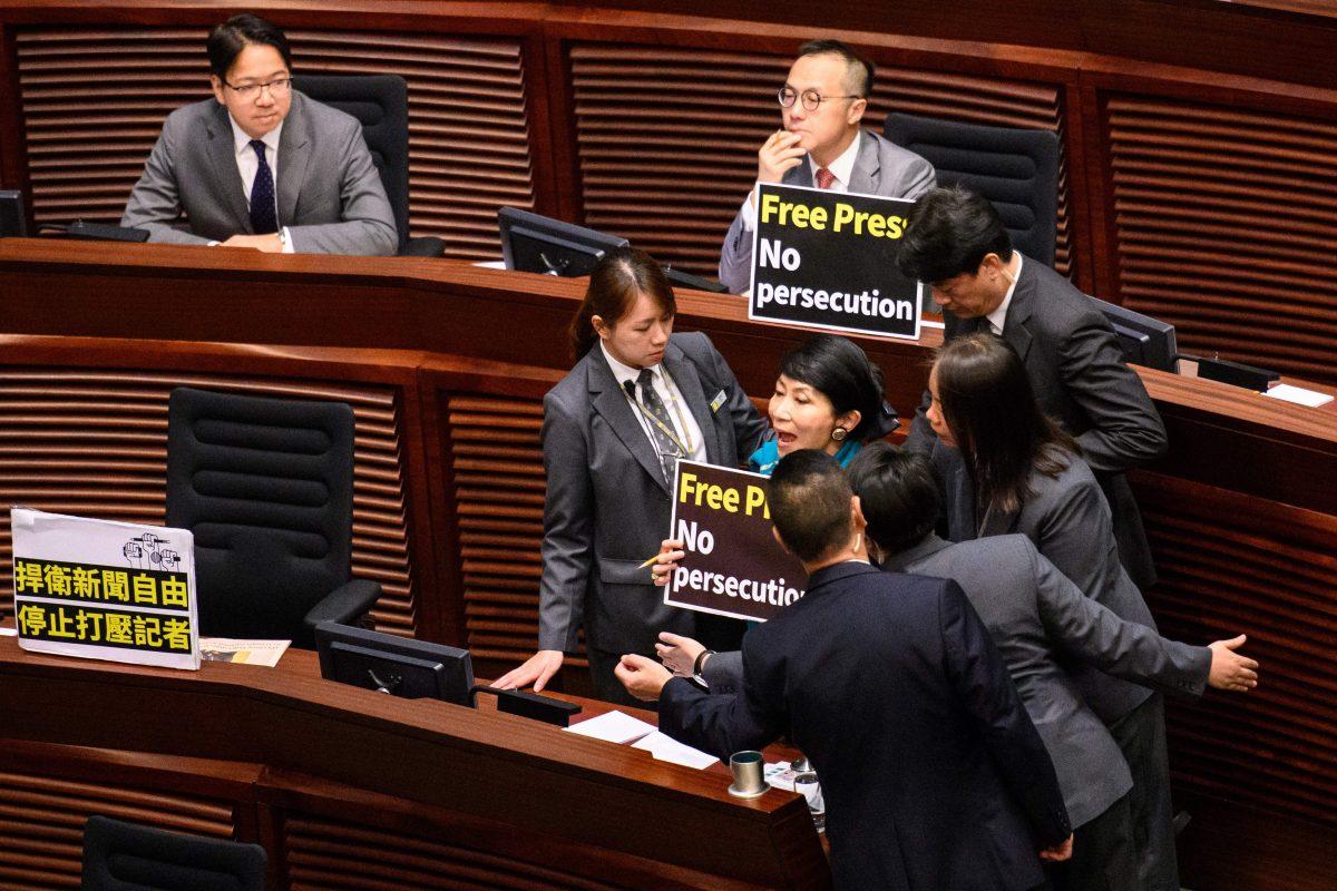 Hong Kong pro-democracy legislator Claudia Mo (R) is surrounded by security as she shouts "Free press! No Persecution!" as Chief Executive Carrie Lam (not pictured) arrives to deliver her policy address at the Legislative Council (Legco) in Hong Kong on October 10, 2018. (Anthony WALLACE / AFP) (Photo credit should read ANTHONY WALLACE/AFP/Getty Images)