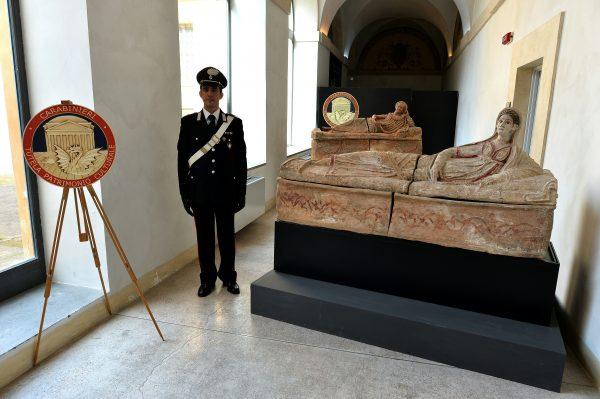 A carabiniere stands next to recovered archaeological artifacts in Rome on March 22, 2016. (Alberto Pizzoli/AFP/Getty Images)