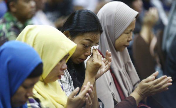 Relatives weep as they pray for victims of the Lion Air jet that crashed into the Java Sea during a press conference in Jakarta, Indonesia, Monday, Nov. 5, 2018. Distraught and angry relatives of those killed when a Lion Air jet crashed last week have confronted the airline's executives during a meeting arranged by Indonesian officials. (AP Photo/Achmad Ibrahim)
