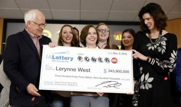 Iowa Lottery CEO Terry Rich (L), presents a check to Lerynne West, of Redfield, Iowa (C), for her share of a nearly $700 million Powerball prize at the Iowa Lottery headquarters in Clive, Iowa, Nov. 5, 2018. (Charlie Neibergall/AP Photo)