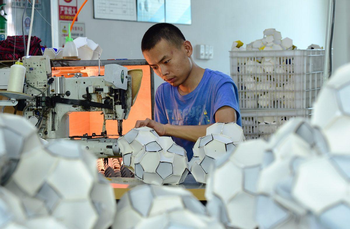 A worker makes footballs that will be exported to Russia and Brazil at a factory in Yiwu in eastern China's Zhejiang province on July 5, 2018. (-/AFP/Getty Images)
