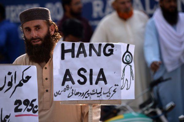  A supporter of Tehreek-e-Labaik, a hard-line, religious political party, holds a placard during a protest in Rawalpindi, Pakistan, on Oct. 12, 2018. (Aamir Qureshi/AFP/Getty Images)