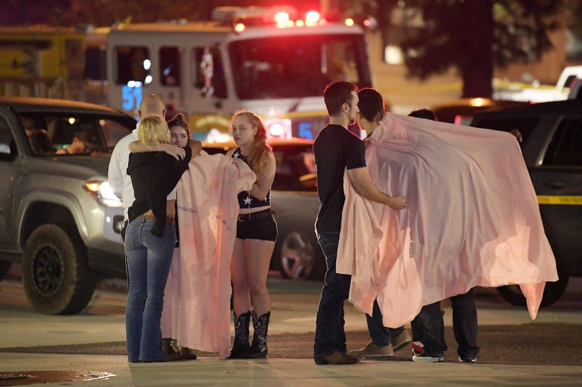 People comfort each other as they stand near the scene of the mass shooting at the Borderline Bar & Grill in Thousand Oaks, Calif., Nov. 8, 2018. (AP Photo/Mark J. Terrill)
