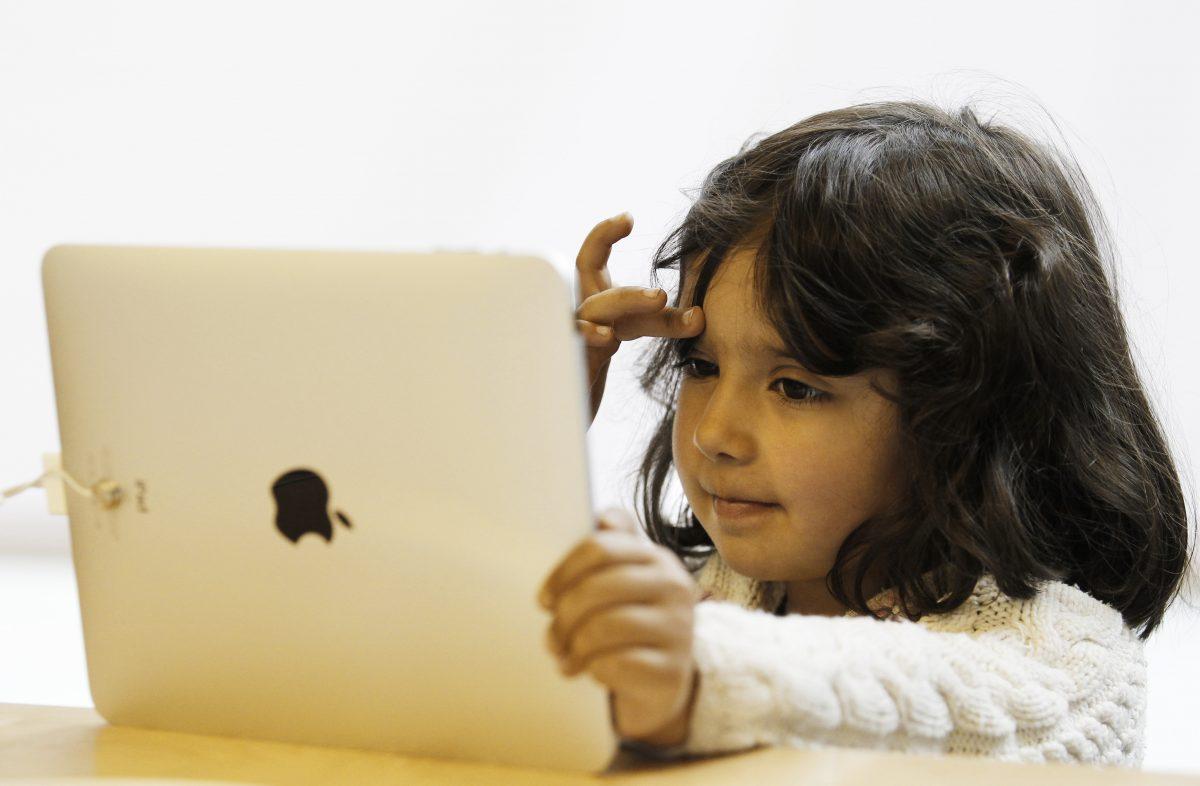 A girl uses an iPad at an Apple store in central London in this file photo. (Reuters/Luke MacGregor)