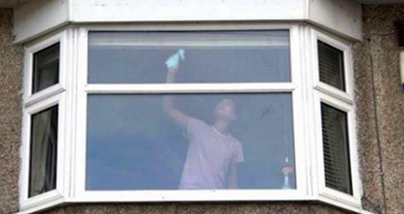 Police in the United Kingdom shared a photo of a woman cleaning a window, but they say there is something wrong with it. (Avon and Somerset Police)