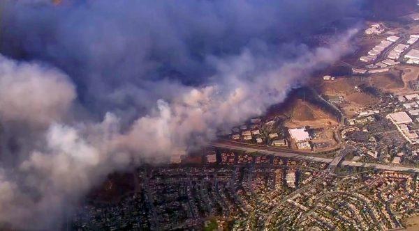 This photo taken from video provided by CBS2/KCAL9 shows a wildfire burning in Camarillo, Calif., on Nov. 8, 2018. Known as the Hill fire, it here has crossed U.S. Highway 101, at center right, potentially threatening hundreds of homes. (CBS2/KCAL9 via AP)