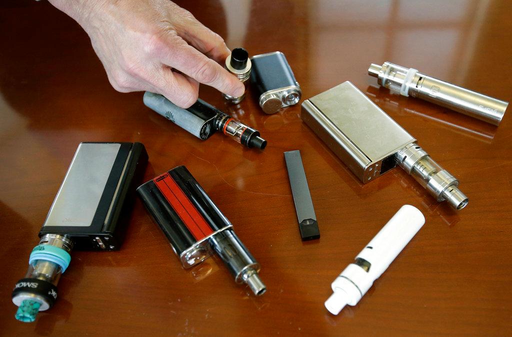 A high school principal displays vaping devices that were confiscated from students in such places as restrooms or hallways at the school in Massachusetts on Apr. 10, 2018. (AP/Steven Senne)