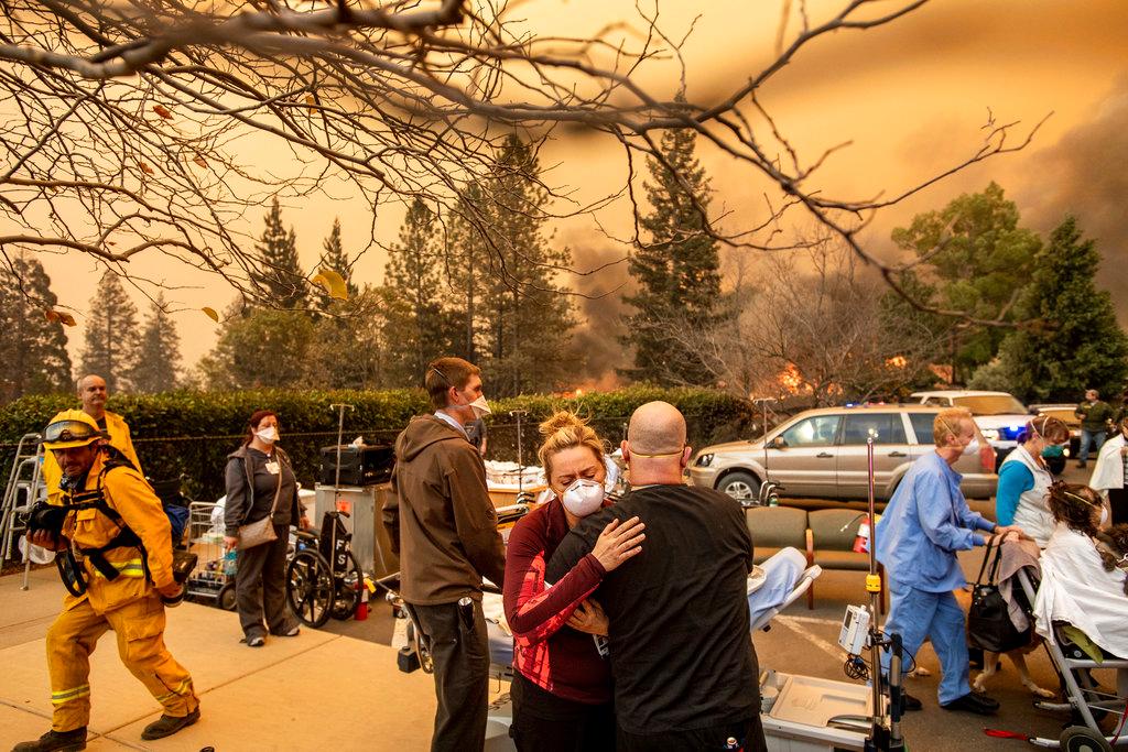 Nurse Cassie Lerossignol hugs as coworker as the Feather River Hospital burns while the Camp Fire rages through Paradise, Calif., on Nov. 8, 2018. (AP/Noah Berger)