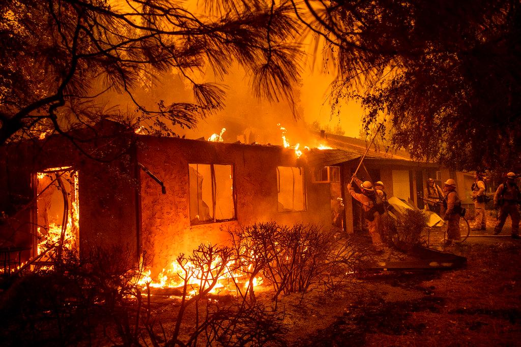 Firefighters work to keep flames from spreading through the Shadowbrook apartment complex as a wildfire burns through Paradise, Calif., on Friday, Nov. 9, 2018. (Noah Berger/AP Photo)