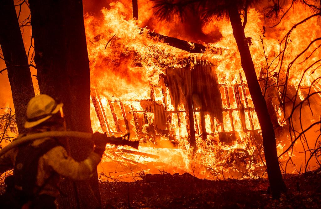 Firefighter Jose Corona monitors a burning home as the Camp Fire burns in Magalia, Calif., on Friday, Nov. 9, 2018. (AP Photo/Noah Berger)