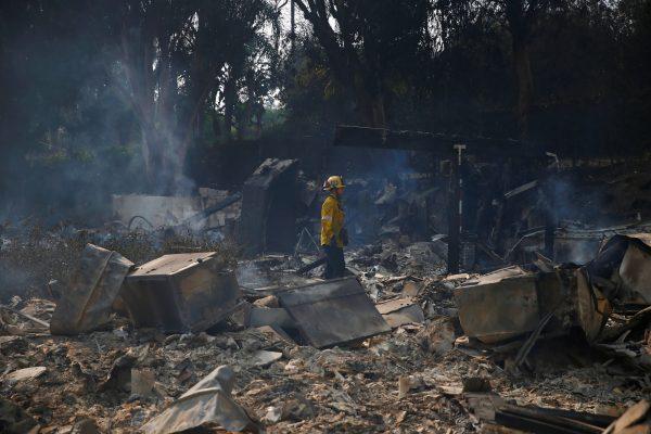 A firefighter stands in the debris of a home destroyed by the Woolsey Fire in Malibu, California, U.S. November 10, 2018. (Eric Thayer/Reuters)