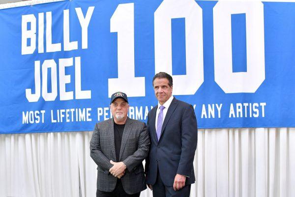 Billy Joel and New York Governor Andrew Cuomo in front of a banner honoring Joel's 100th Lifetime Performance at Madison Square Garden in New York City on July 18, 2018. (Michael Loccisano/Getty Images)