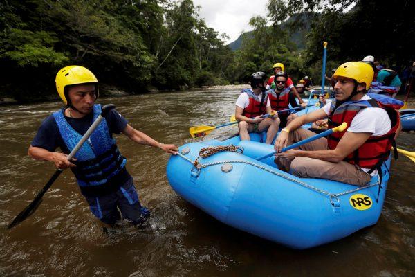 A group of the press and government representatives board an inflatable raft before practicing rafting in Miravalle, Colombia on Nov. 9, 2018. (Luisa Gonzalez/Reuters)